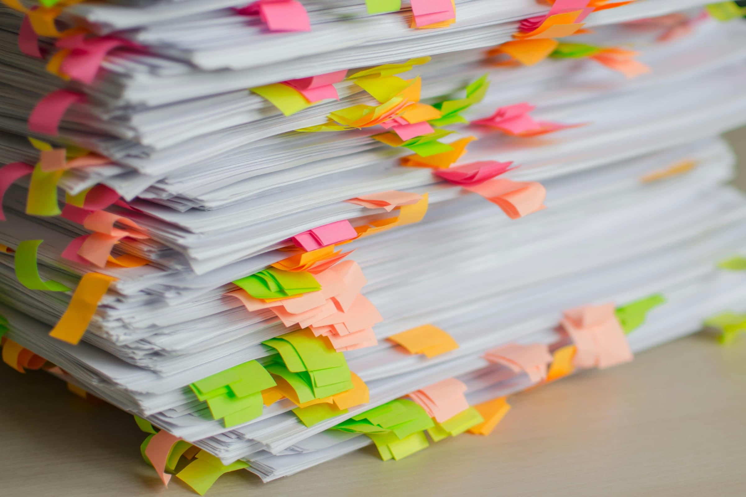 A close-up of a stack of printed pages, each edge marked with colorful sticky tabs.